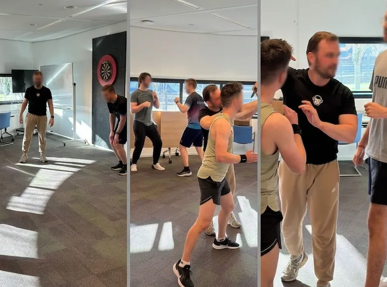 Workshop zelfverdediging bij CBS in een vergaderruimte: deelnemers oefenen slagen en de instructeur begeleidt