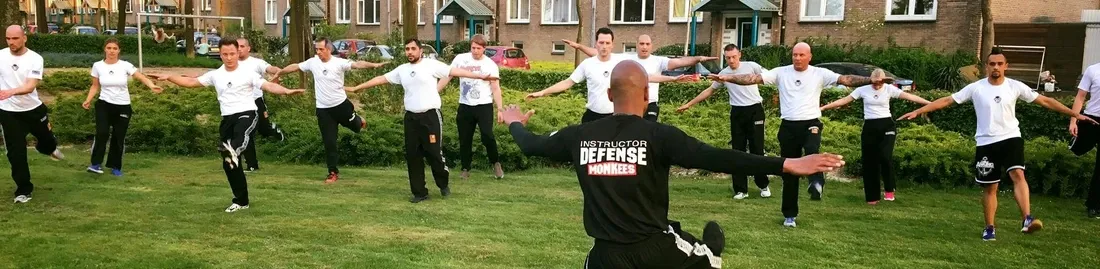 Deelnemers oefenen samen tijdens een Krav Maga workshop in de buitenlucht